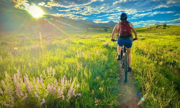 Person biking on a singletrack trail cutting through the prairie in Fort Collins, Colorado