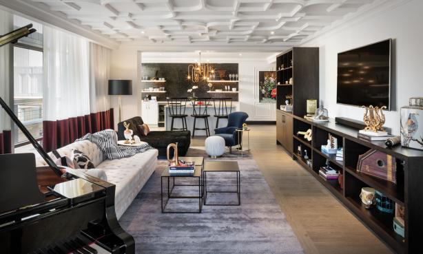 The Music Suite at the Elizabeth Hotel with a decorative moulding on the ceiling, a baby grand piano, a kitchenette and a cosy vibe created from a vast assortment of throw pillows and music-themed decorations