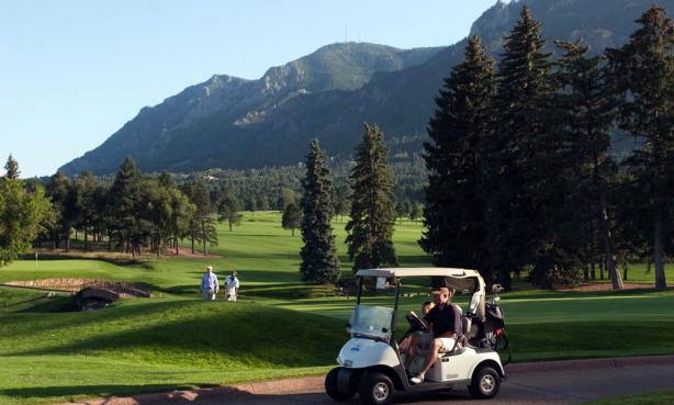 Golf cart on a golf course with mountains in the background