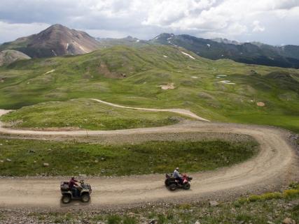 Two ATVs drive on a trail near Engineer Pass - near Ouray, CO