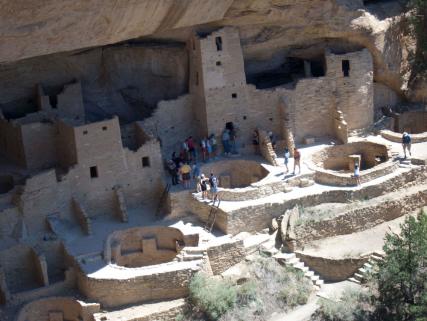 Visitors tour ancestral Puebloan cliff dwellings at Mesa Verde National Park near Cortez