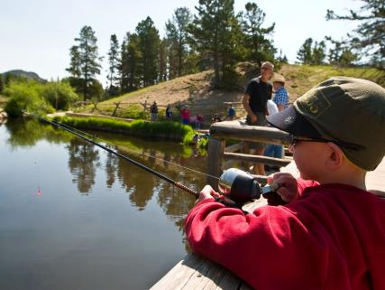 A little boy fishes with his family in Rocky Mountain National Park - Estes Park, CO and Grand Lake, CO