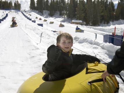 A child finishes a snow-tubing run at Vail Mountain - Vail, CO