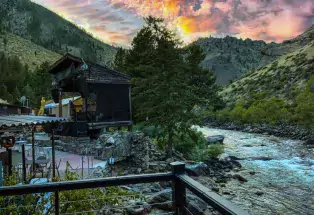 Sun setting behind the mountains as the river runs past the Mish