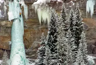 A climber scales a frozen waterfall near Vail.