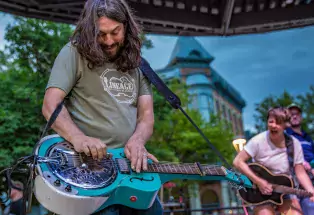 Person playing steel guitar on a stage