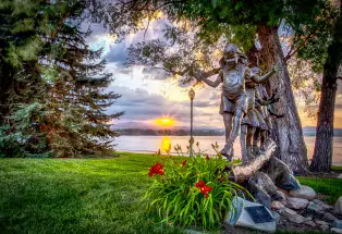 Bronze sculpture of children walking over a log