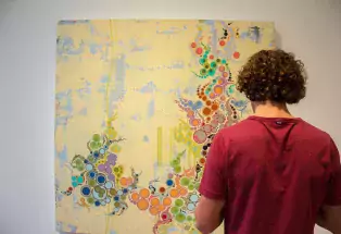 Man looks at painting at First Friday at Denver's Art District on Santa Fe