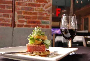 Tuna dish and a glass of red wine at Jax Fish House