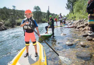 Kids paddleboarding on the Arkansas River