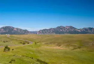 Boulder's Flatiron mountains rise above a green meadow