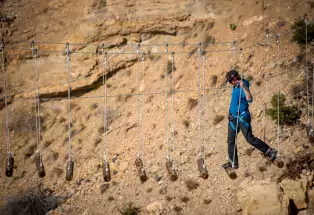 Crossing a suspended bridge at a Salida aerial park