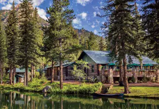 The Broadmoor Fly-Fishing Camp set alongside a creek among evergreens