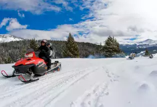 Snowmobiler rides red sled in Colorado's backcountry