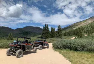 Side-by-sides making their way up a mountain trail