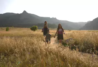 Family hiking Chautauqua Trail at dusk.