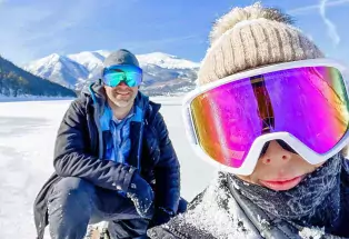 Couple pauses for a snowshoe selfie near Leadville with mountains in the background.