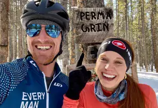 Fat bikers happily pause on Leadville's Perma-Grin mountain-bike trail for a selfie with the trail sign with trees and snow in the background..