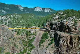 Durango Train snaking along a high cliff in summertime