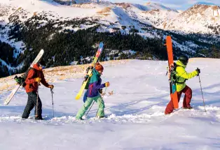 Three people with skis explore Colorado's back country.