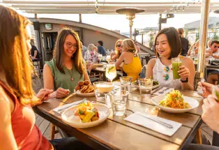 Women enjoy rooftop dining and cocktails at Boulder's Rosetta Hall