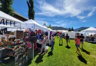 White vendor tents set up at the summer Arts & Crafts Fair in Grand Lake, Colorado