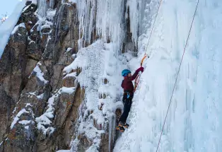 A woman scales the ice at the Lake City Ice Climbing Festival