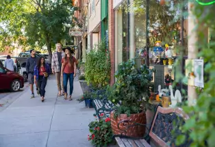 A group of happy friends walks the sidewalks of downtown Cañon City on a sunny day.