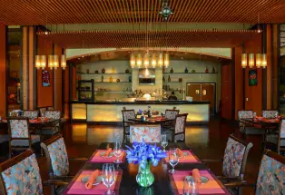 The emtdy dining area at Jill’s Restaurant at St. Julian Hotel and Spa, with hanging lights and bright-pink placemats