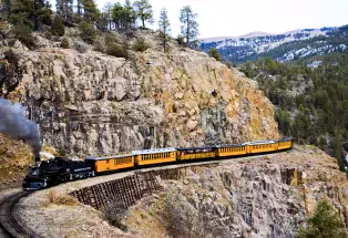 A plume of smoke erupts from the Durango and Silverton Narrow Gague Railroad as it snakes through Southwest Colorado