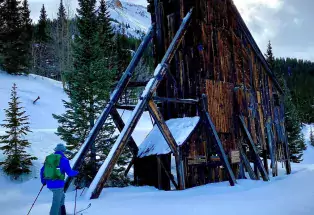 A person snowshoes past historical mining ruins near Montrose, Colorado. 