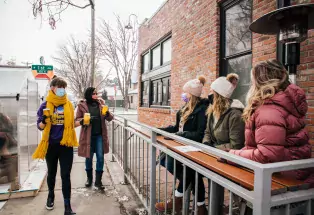 People sip beers outside of Novel Strand Brewery in Denver