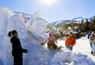 Kids play on the artworak at the Breckenridge Snow Sculpture Competition in Breckenridge, Colorado