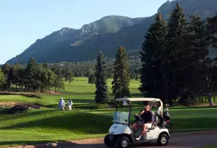 Golf cart on a golf course with mountains in the background