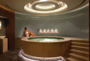 Woman lounging next to a hot tub