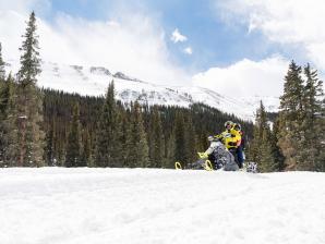 Snowmobiling in the Collegiate Peaks with mountains in forest in the background
